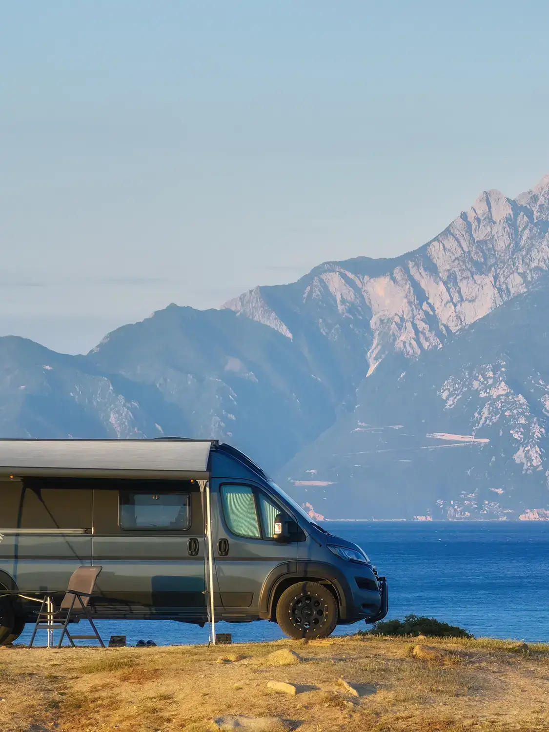 Van devant un lac avec montagne en arrière-plan